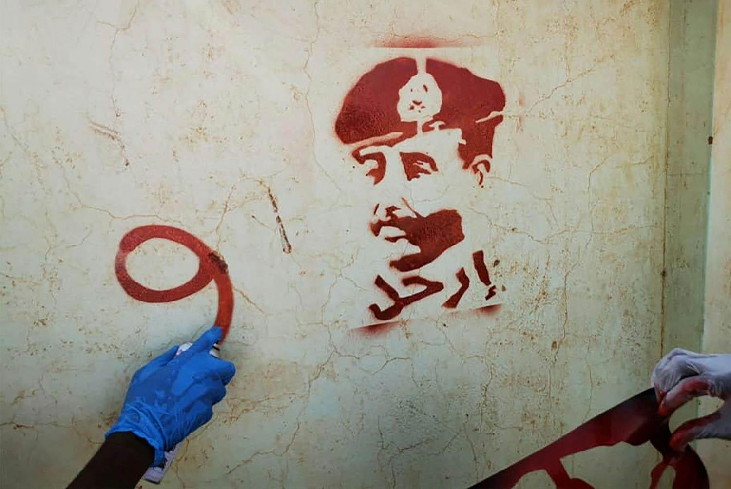 سودانيون يخطون ارحل مع صورة قائد الجيش عبدالفتاح البرهان