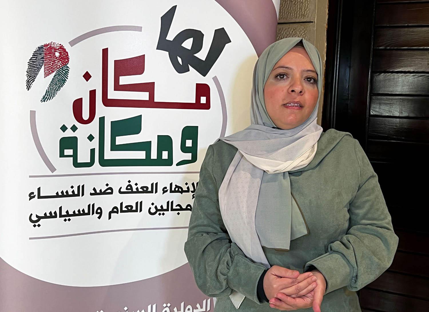 ناشطة أردنية مع ملصق لجمعية المرأة في الأردن