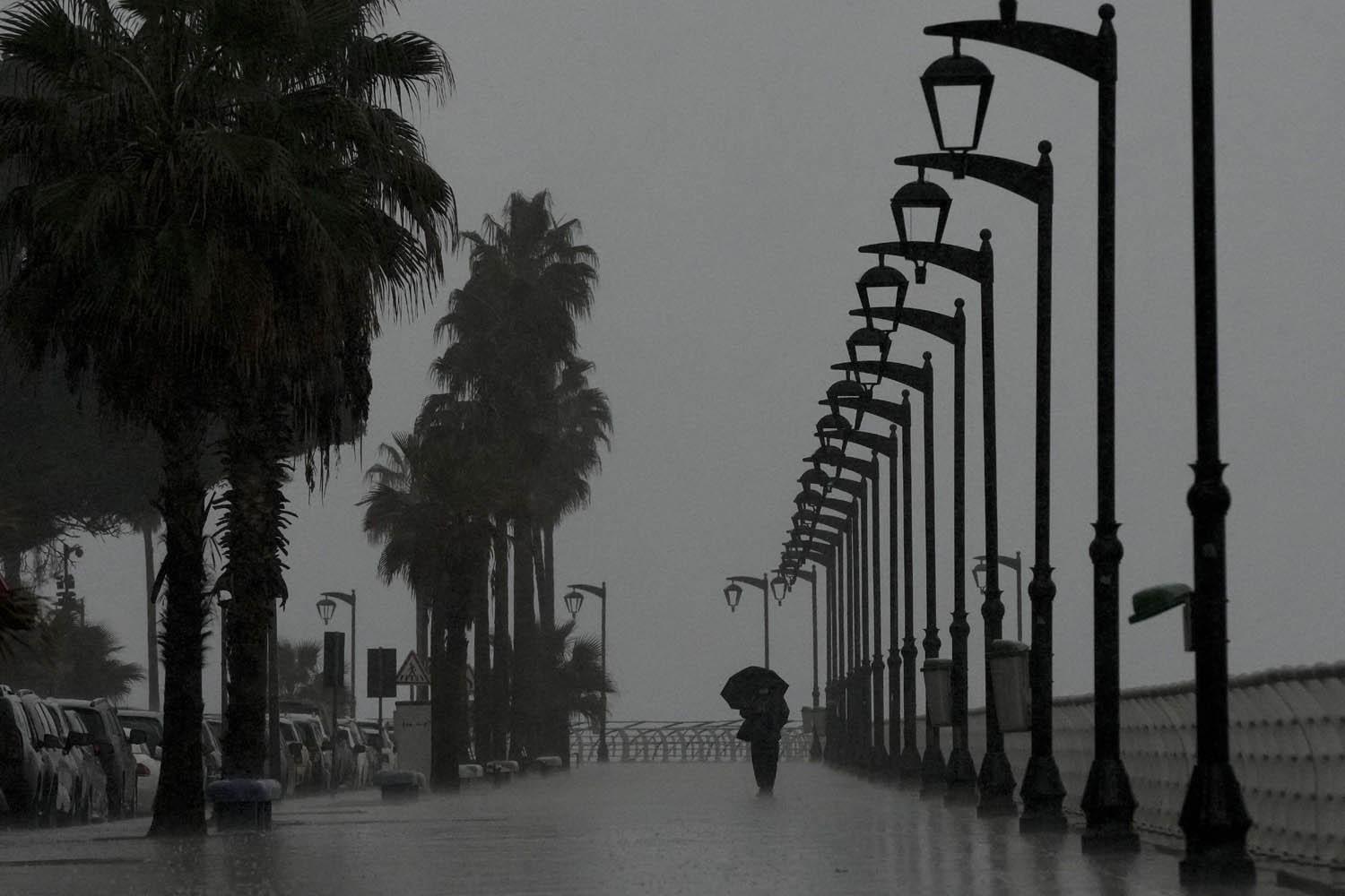 لبناني يمشي على كورنيش بيروت برغم الامطار الشديدة
