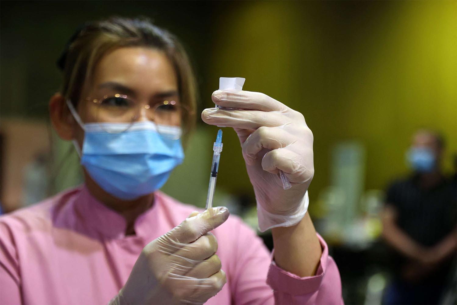 A health worker prepares a dose of the COVID-19 vaccine in Doha