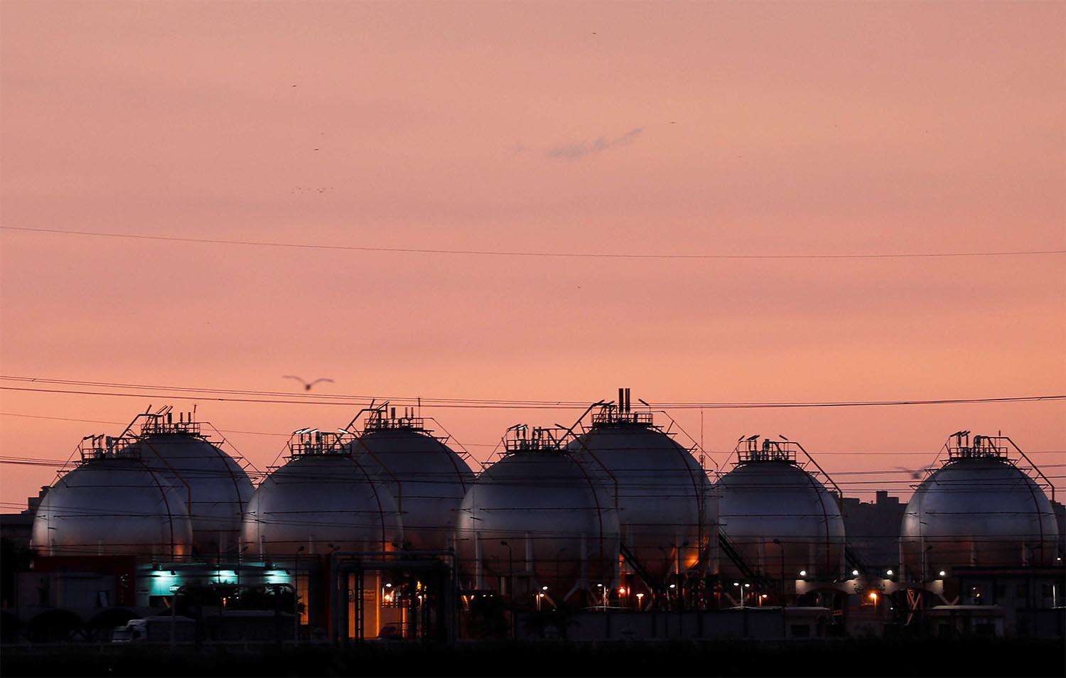 A plant's gas tanks are seen during sunset along a highway of Alexandria