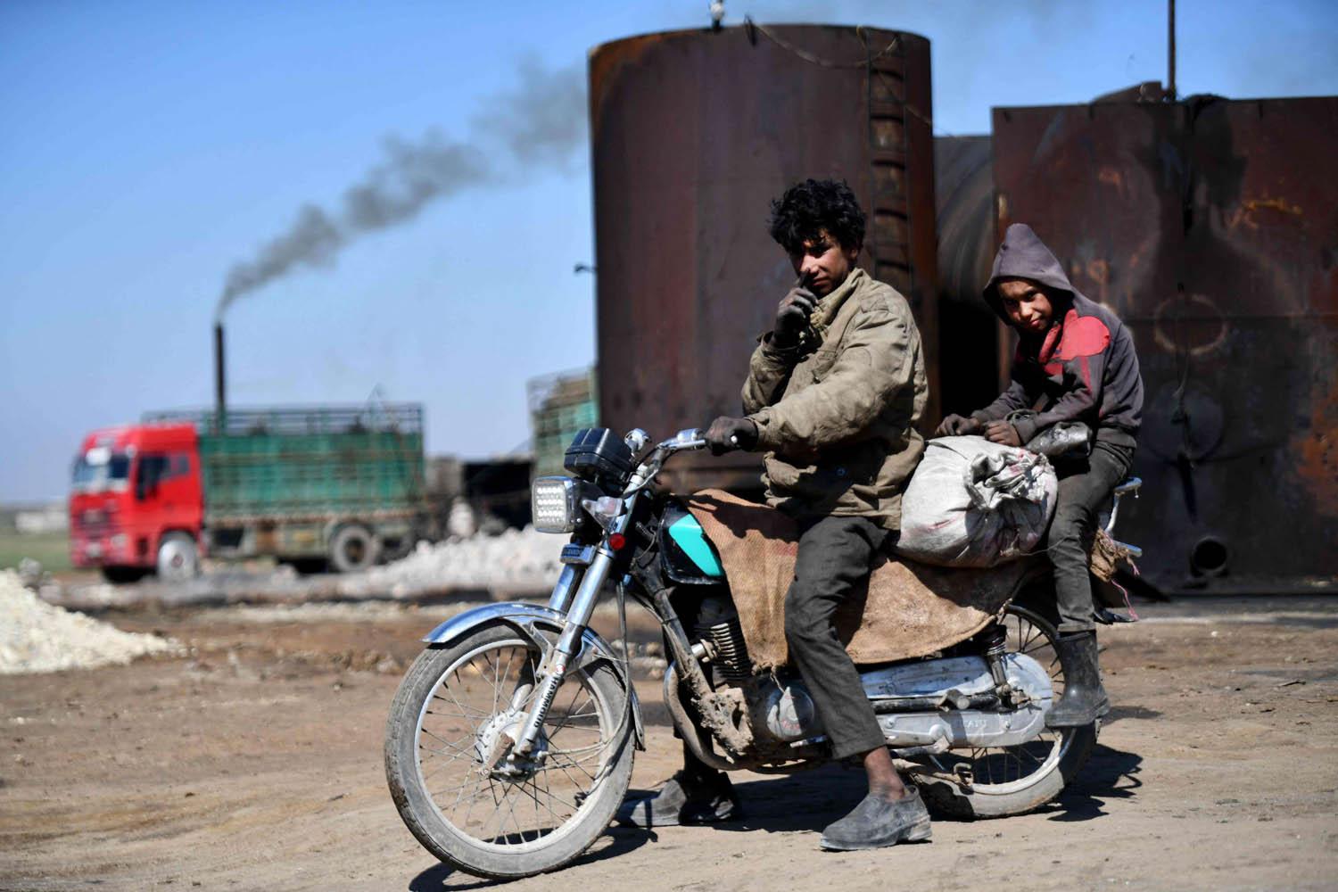 مراهقون سوريون يعملون في مصفاة بدائية للنفط في مدينة الباب قرب حلب