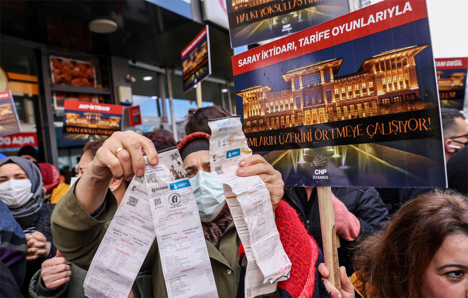 A woman displays her utility bills during a protest against high energy prices in Istanbul