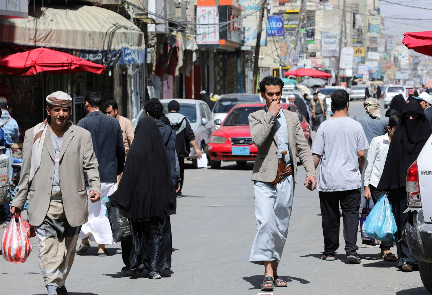 People walk on a street hours before a two-month nationwide truce takes effect in Sanaa