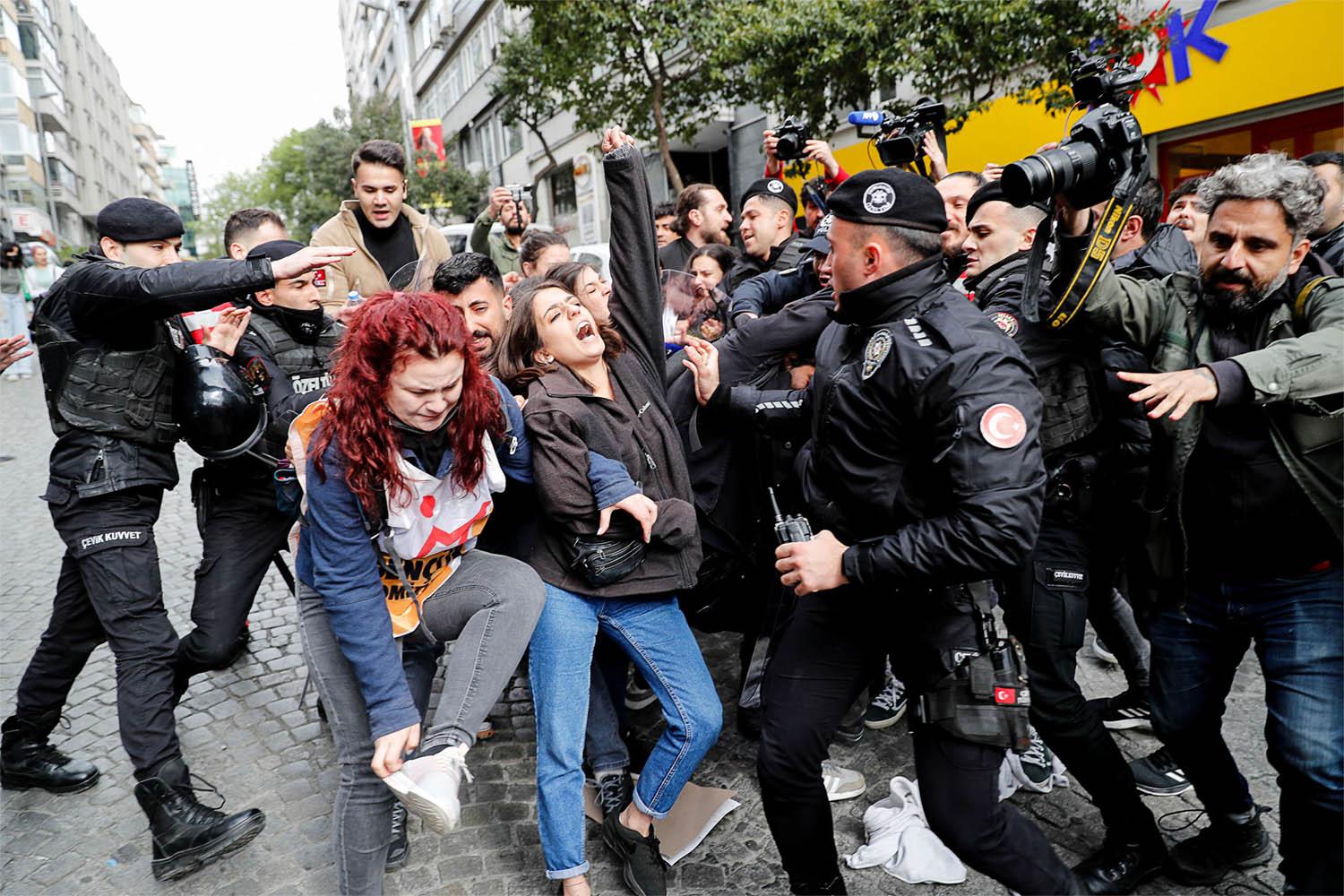 Police officers scuffle with a group of protesters in Istanbul