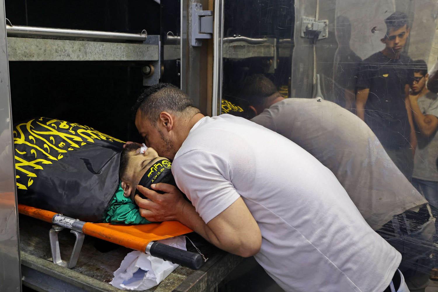 فلسطيني يقبل جثمان ناشط قتل في غارة أمنية إسرائيلية في جنين