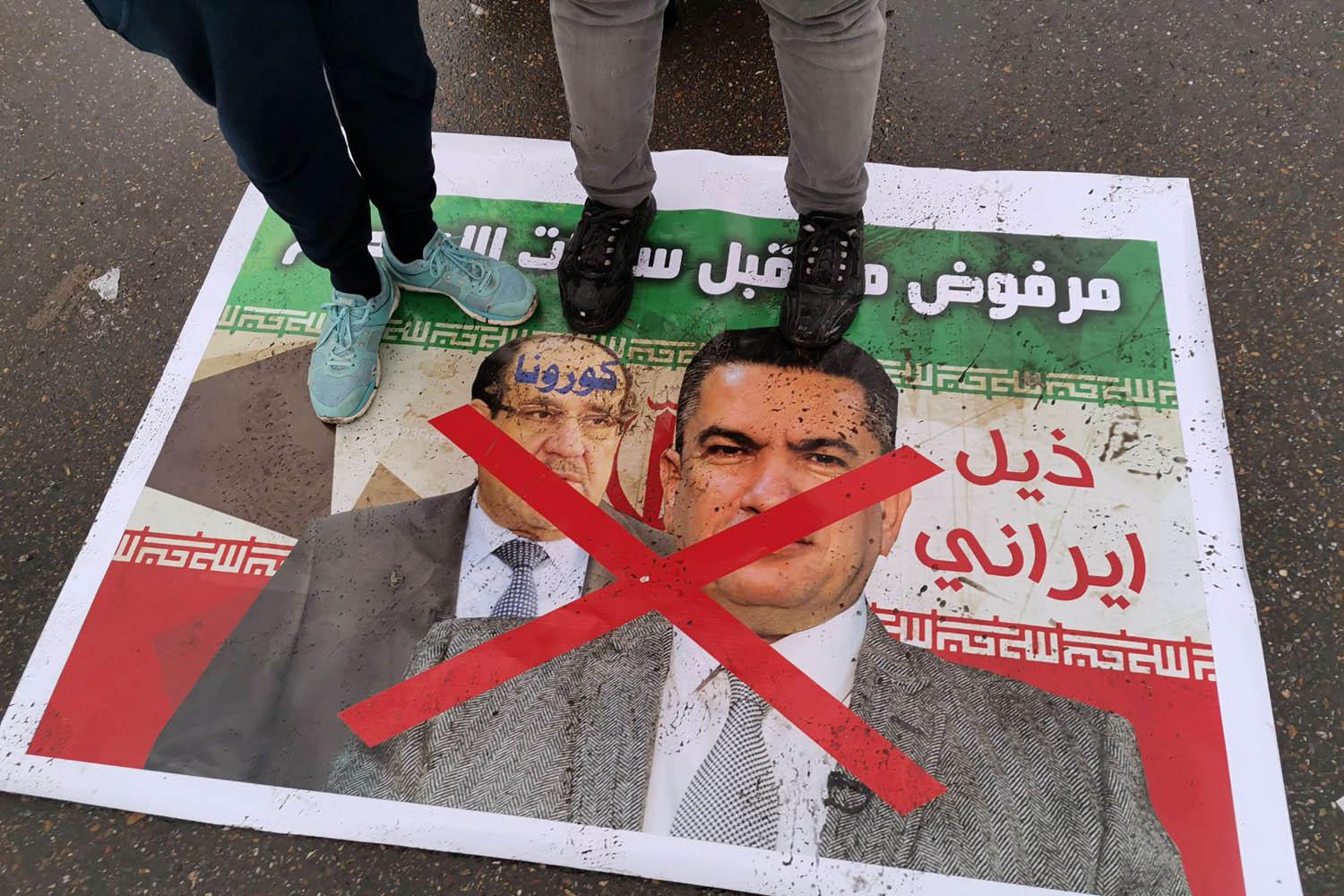 عراقيون يدوسون على صور لرئيس الوزراء العراقي السابق نوري المالكي ولأحد حلفائه السياسيين