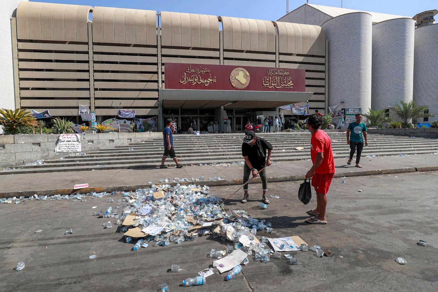 عمال البلدية ينظفون آثار الاعتصام أمام البرلمان العراقي