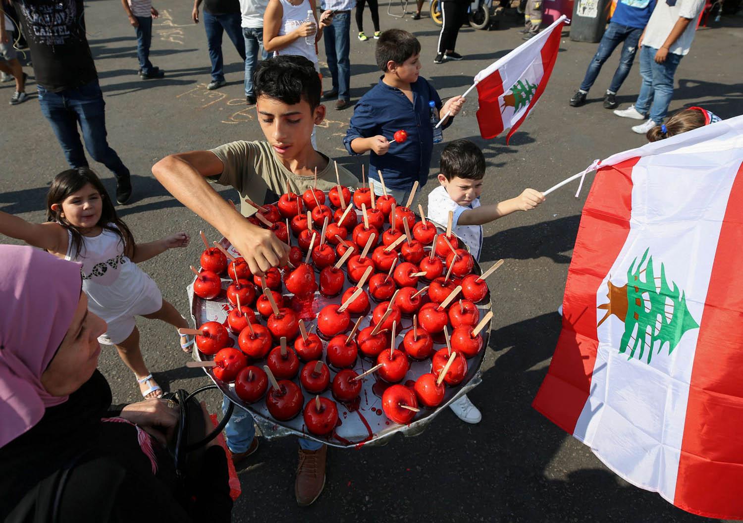 طفل يبيع تفاحا أثناء تظاهرة ي صيدا، جنوب لبنان