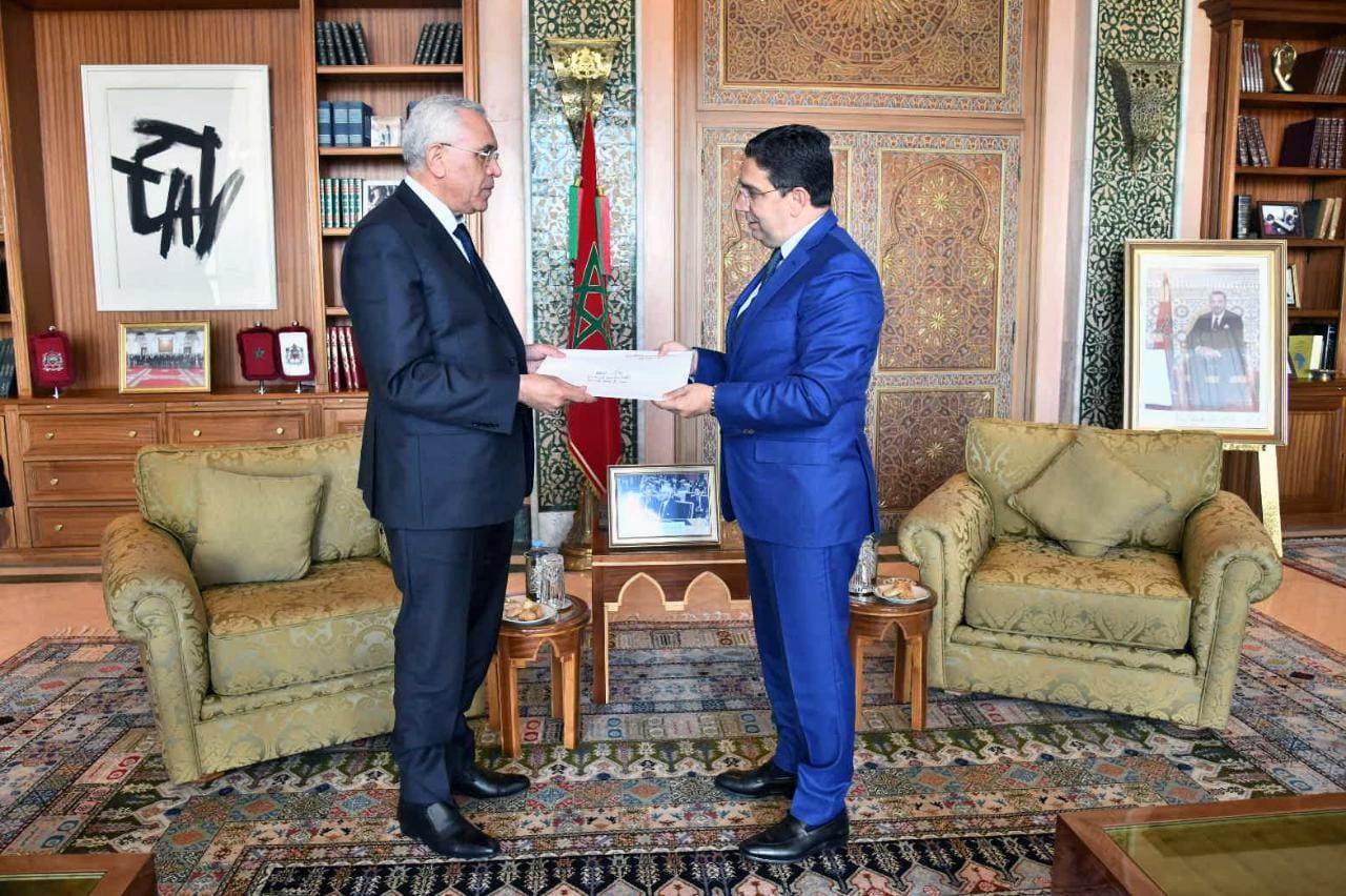 Algerian Minister of Justice Abderrachid Tabi, left, hands a letter of invitation extended to King Mohammed VI, to Morocco's Foreign Minister Nasser Bourita