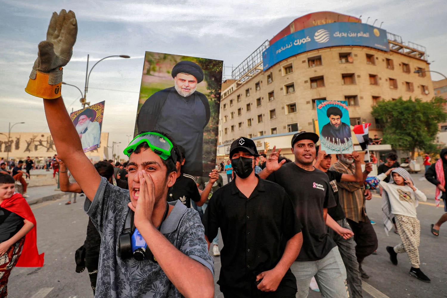 محتجون عراقيون يرفعون صورة مقتدى الصدر