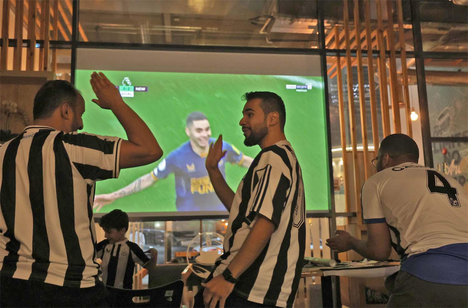 Saudi fans of Newcastle United celebrate a goal scored against Tottenham 