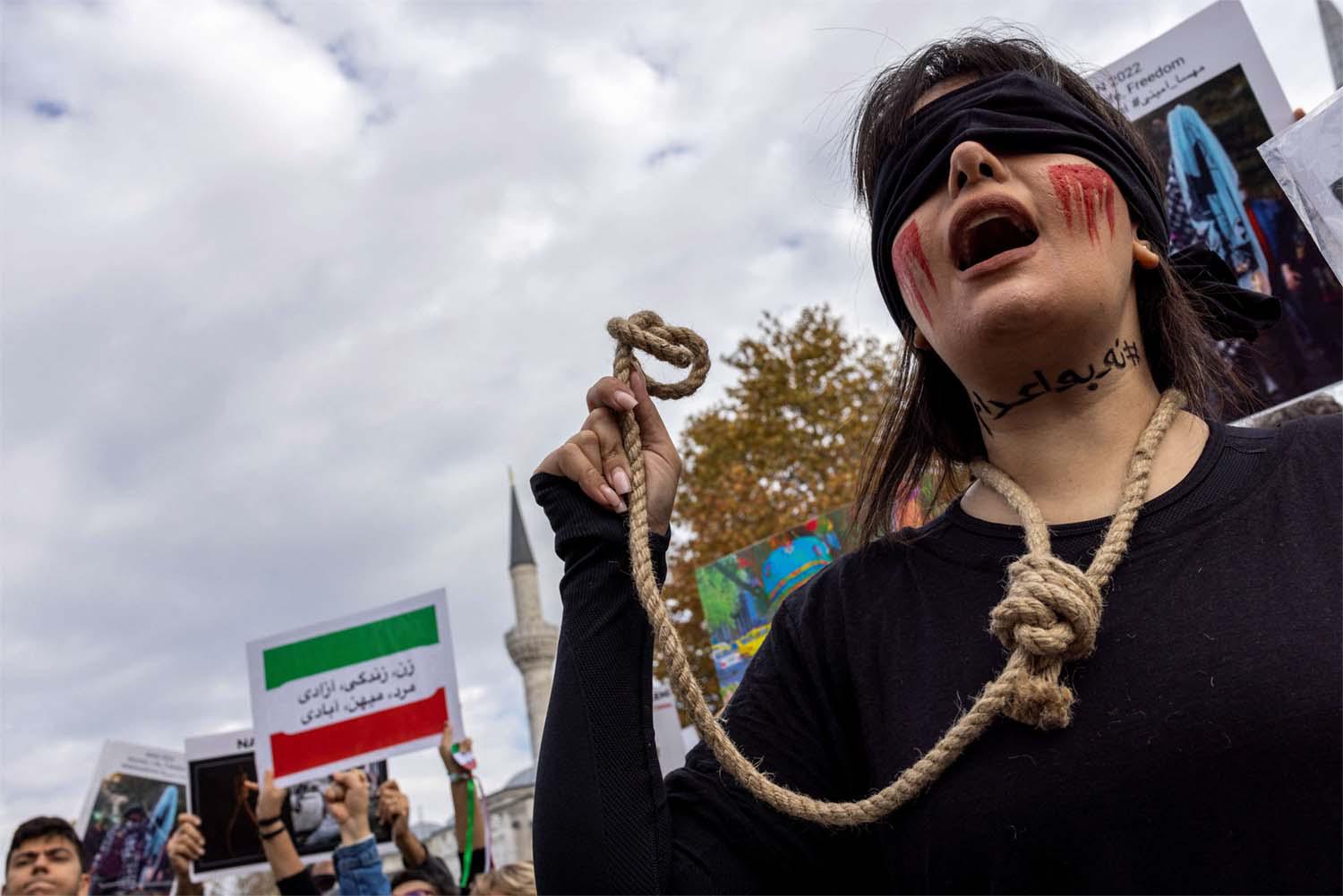 A member of the Iranian community living in Turkey holds a rope as letters on her neck reads, #no to death penalty during a protest