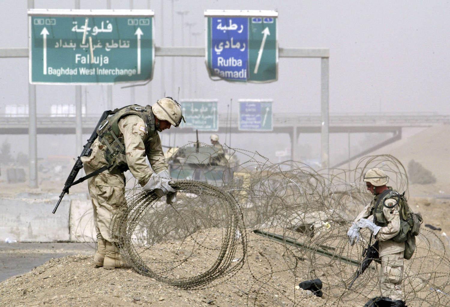 جنود أميركيون يضعون اسلاكا شائكة لعزل الفلوجة (2004)