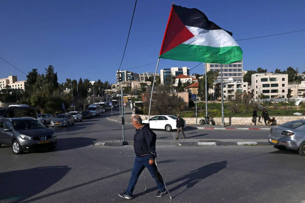 فلسطيني يحمل علما فلسطينيا في احتجاج في الشيخ جراح في القدس
