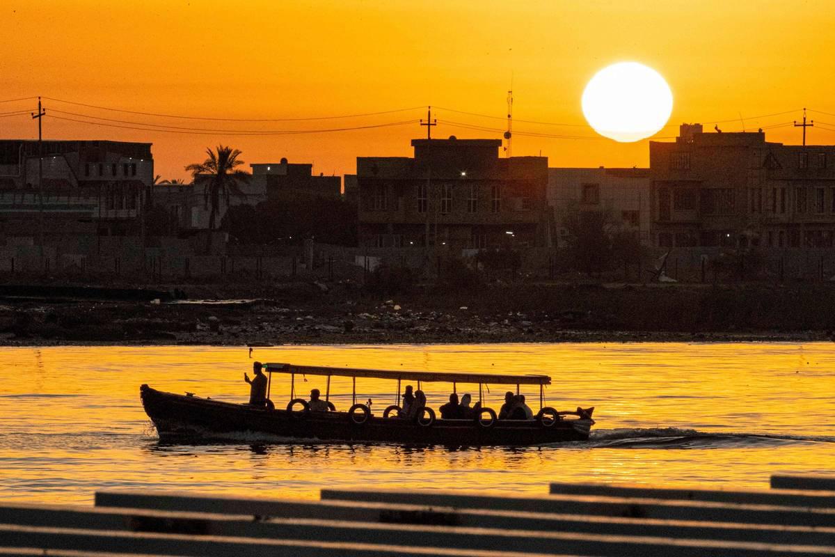 قارب يعبر دجلة وقت الغروب في بغداد
