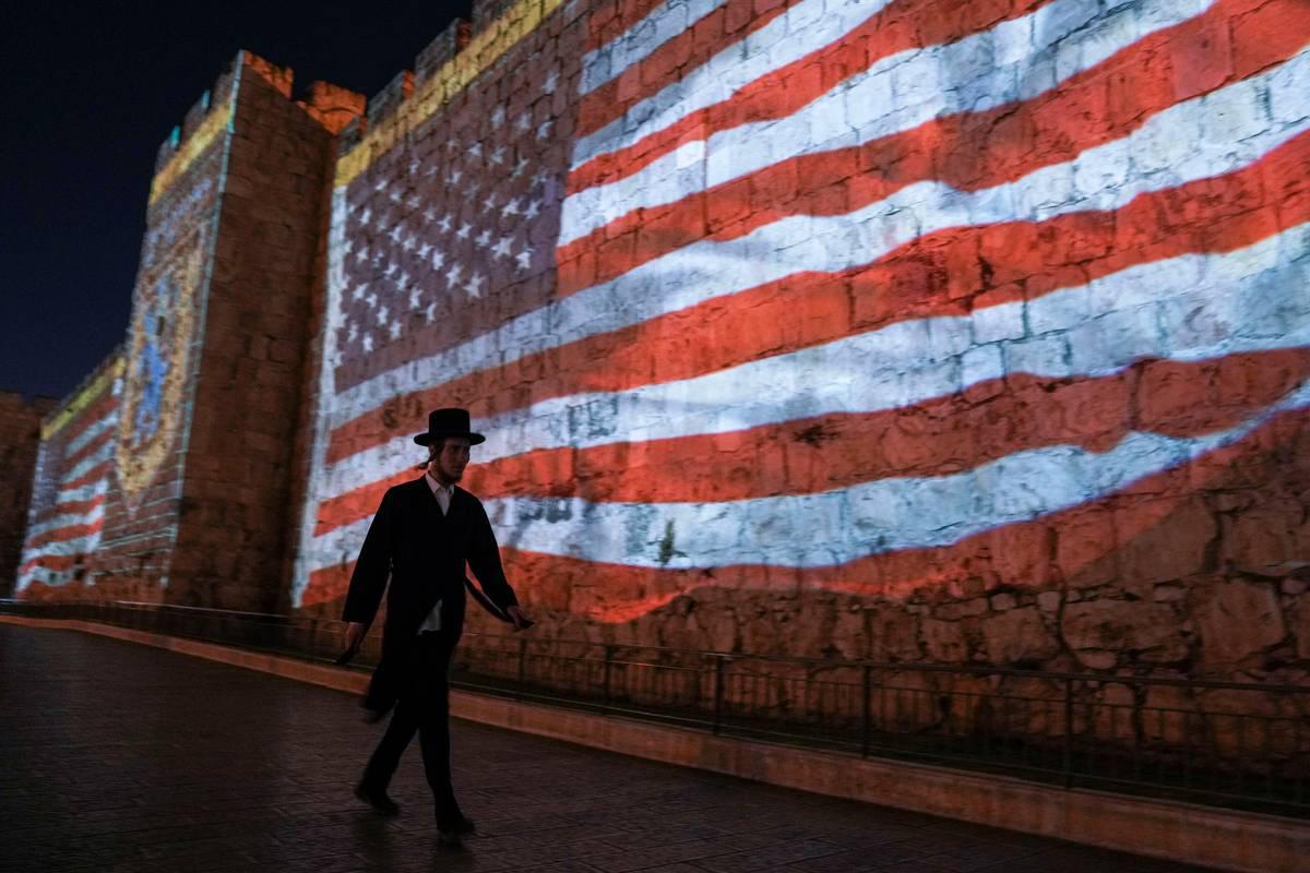 إسرائيلي يمر بجانب علم أميركي في القدس