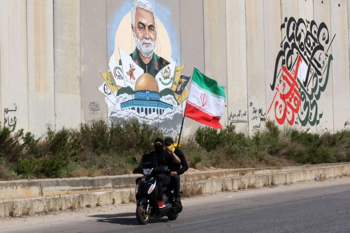 لبنانيون يستعرضون العلم الإيراني على الحاجز الفاصل عن إسرائيل في جنوب لبنان