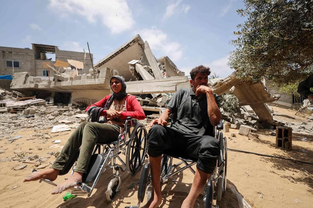 عائلة فلسطينية أمام منزلها المدمر بالقصف الإسرائيلي على غزة