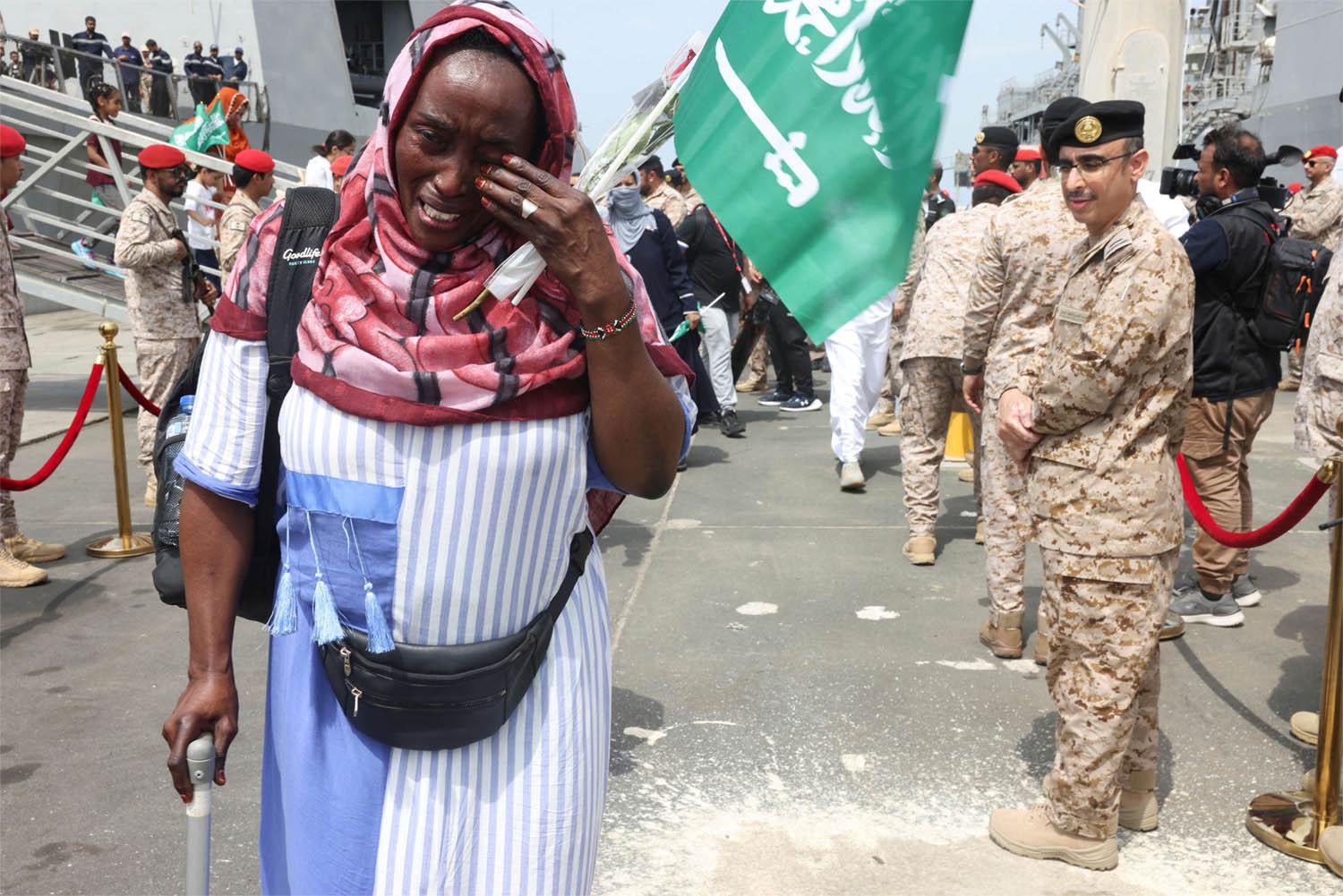 A Sudanese woman cries as she disembarks from Saudi Navy Ship with people from different nationality evacuated to Saudi Arabia from Sudan