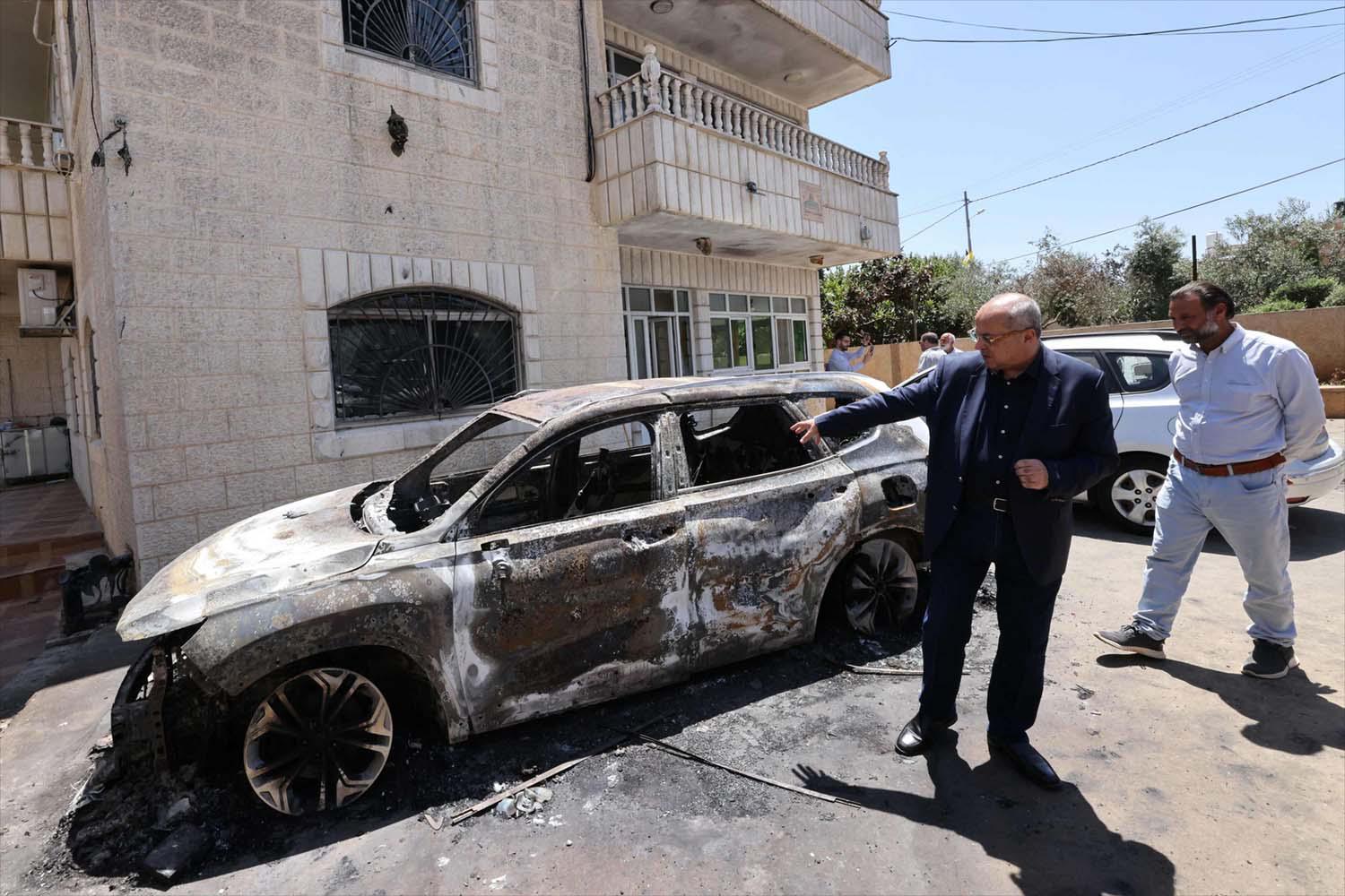 ab-Israeli Knesset member Ahmed Tibi inspects the damage at the site of an attack by Israeli settlers on the village of Turmus Ayya 