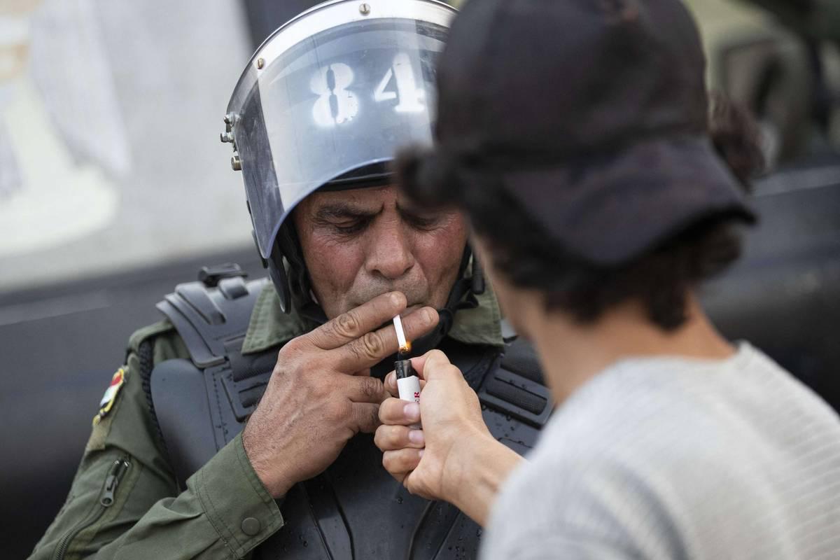 متظاهر مع شرطي عراقي في بغداد