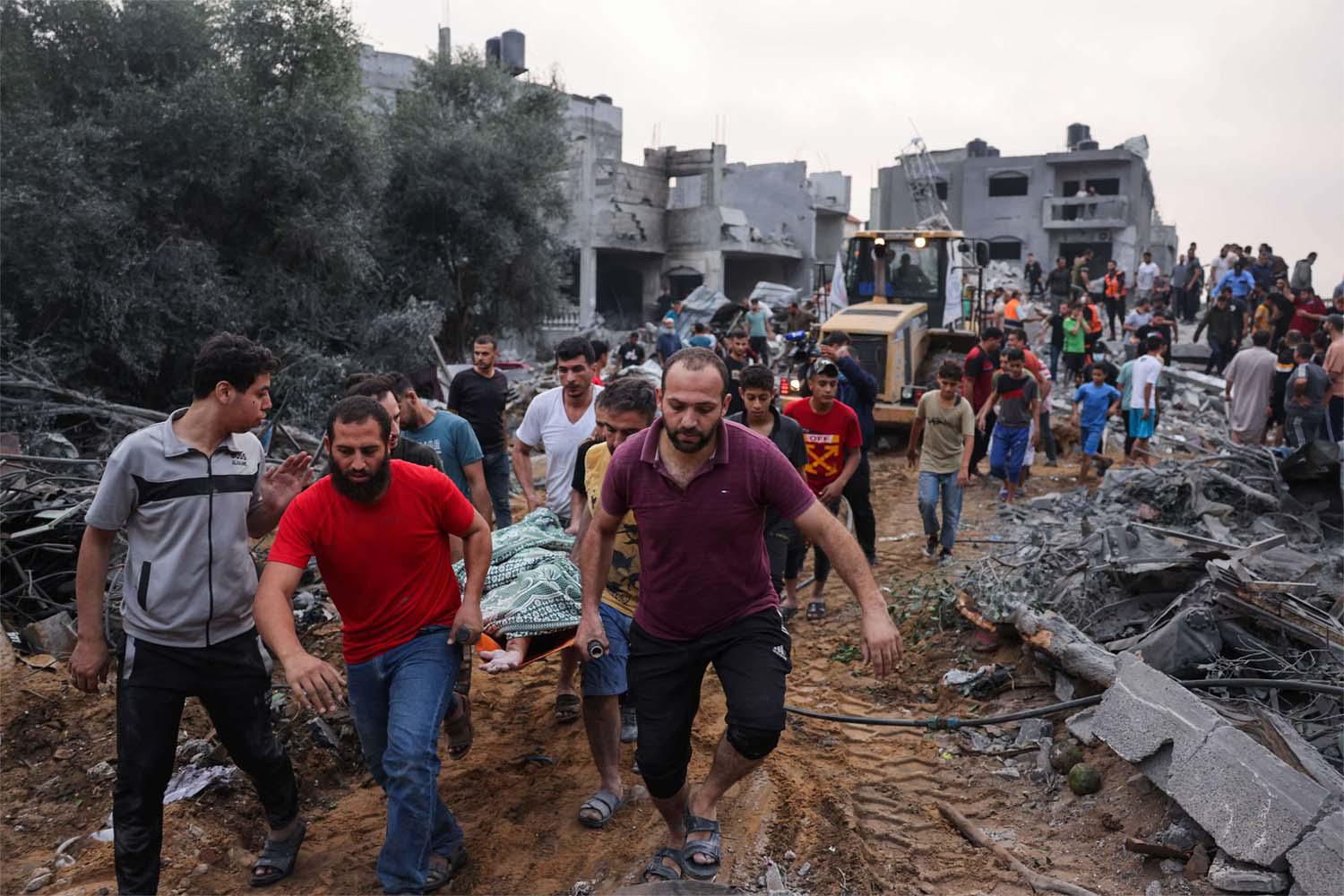 Palestinians transport the body of a victim from the rubble after Israeli strikes in Rafah