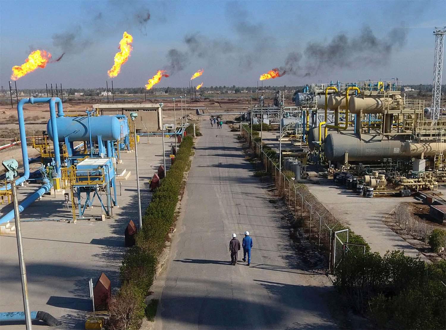 Labourers walk down a path in the Nihran Bin Omar field north of Basra