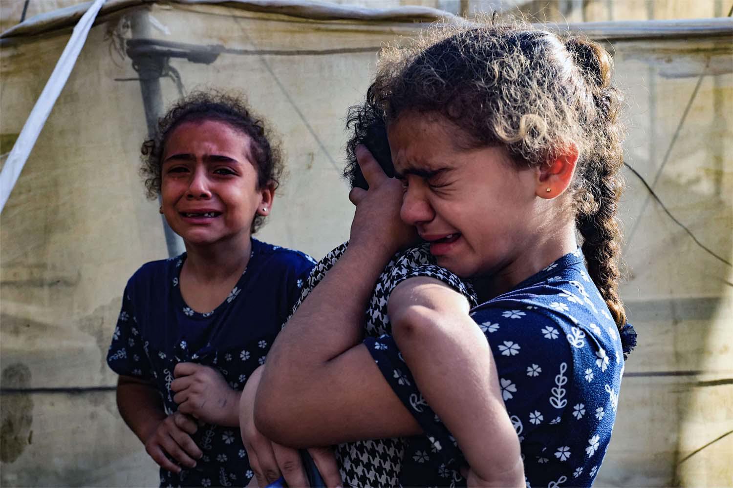 Children cry during the funeral of the Faojo family, killed in Israeli bombing on Rafah 