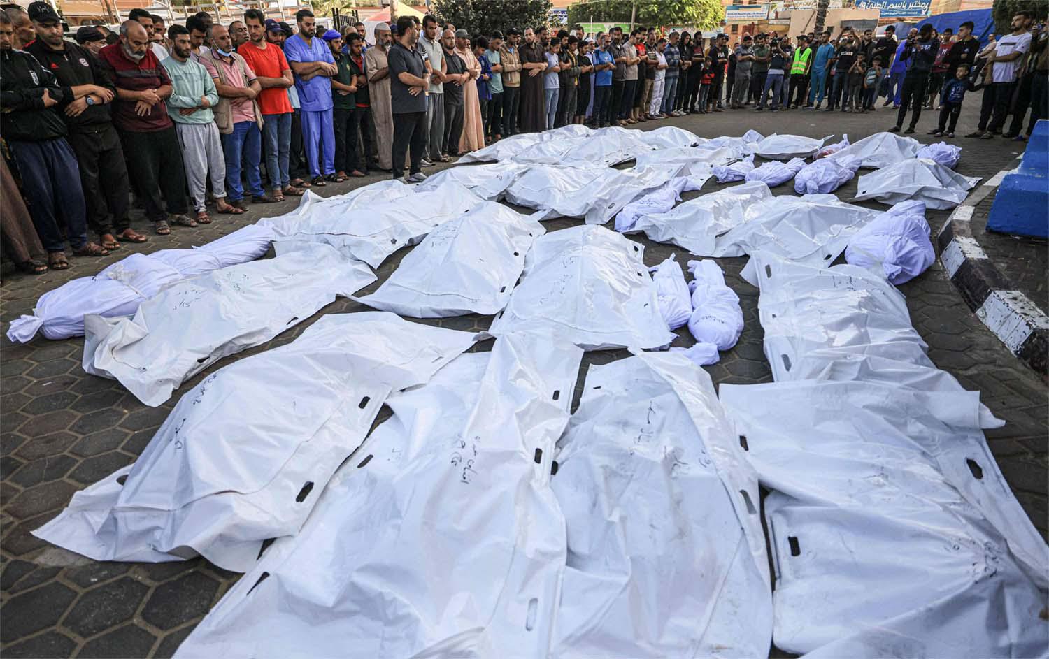 Palestinians gather as they mourn over the bodies of those killed in Israeli bombardment in Deir Balah in the central Gaza Strip