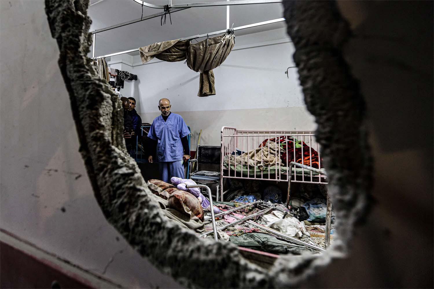People inspect the damage in a room following Israeli bombardment at Nasser hospital in Khan Younis