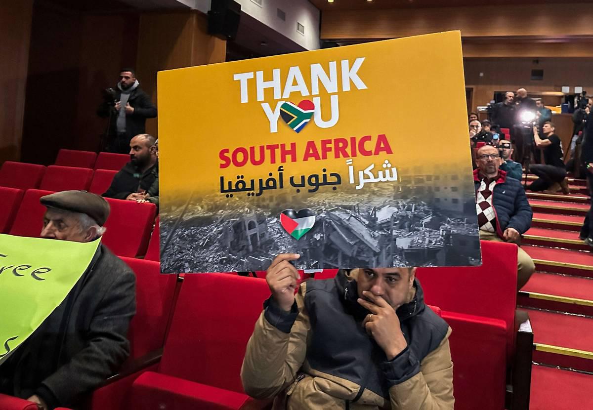 ناشط يرفع لافتة تأييد لإنجاز جنوب أفريقيا بإدانة إسرائيل في محكمة العدل الدولية