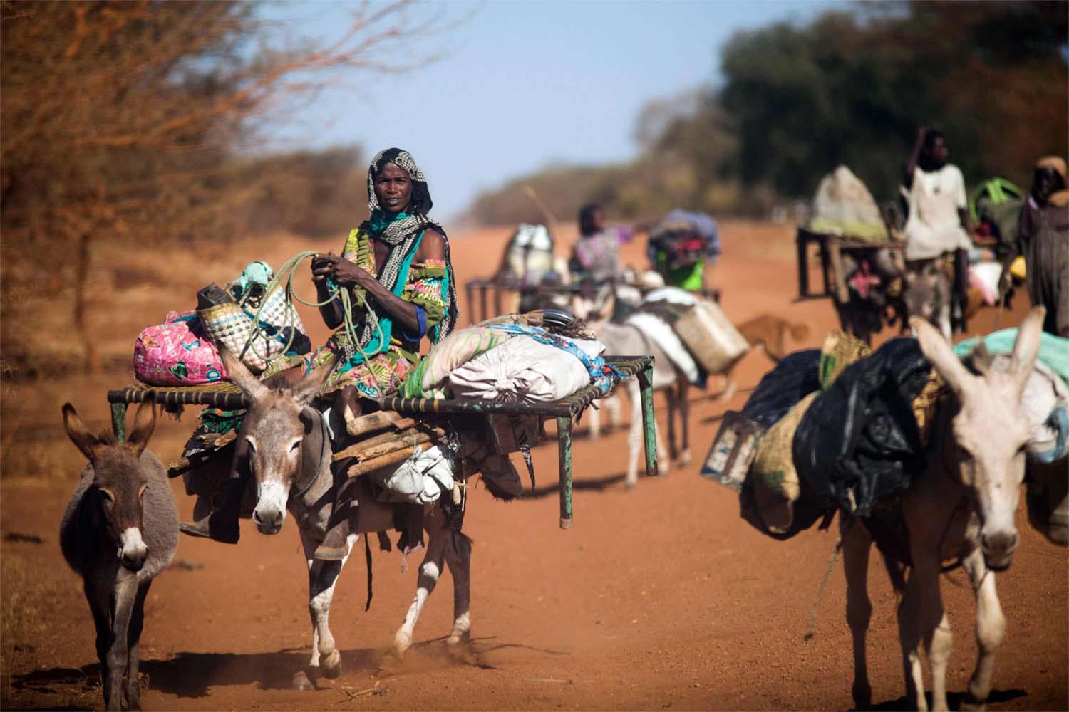 A woman rides a donkey as nomad families from the Misseryia area in Abyei region