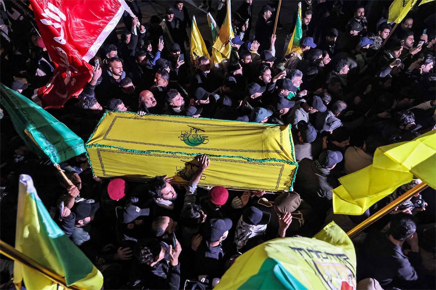 Members of Iraq's Popular Mobilisation Forces (PMF) paramilitaries carry the bodies of two of their slain comrades during their funeral in Baghdad