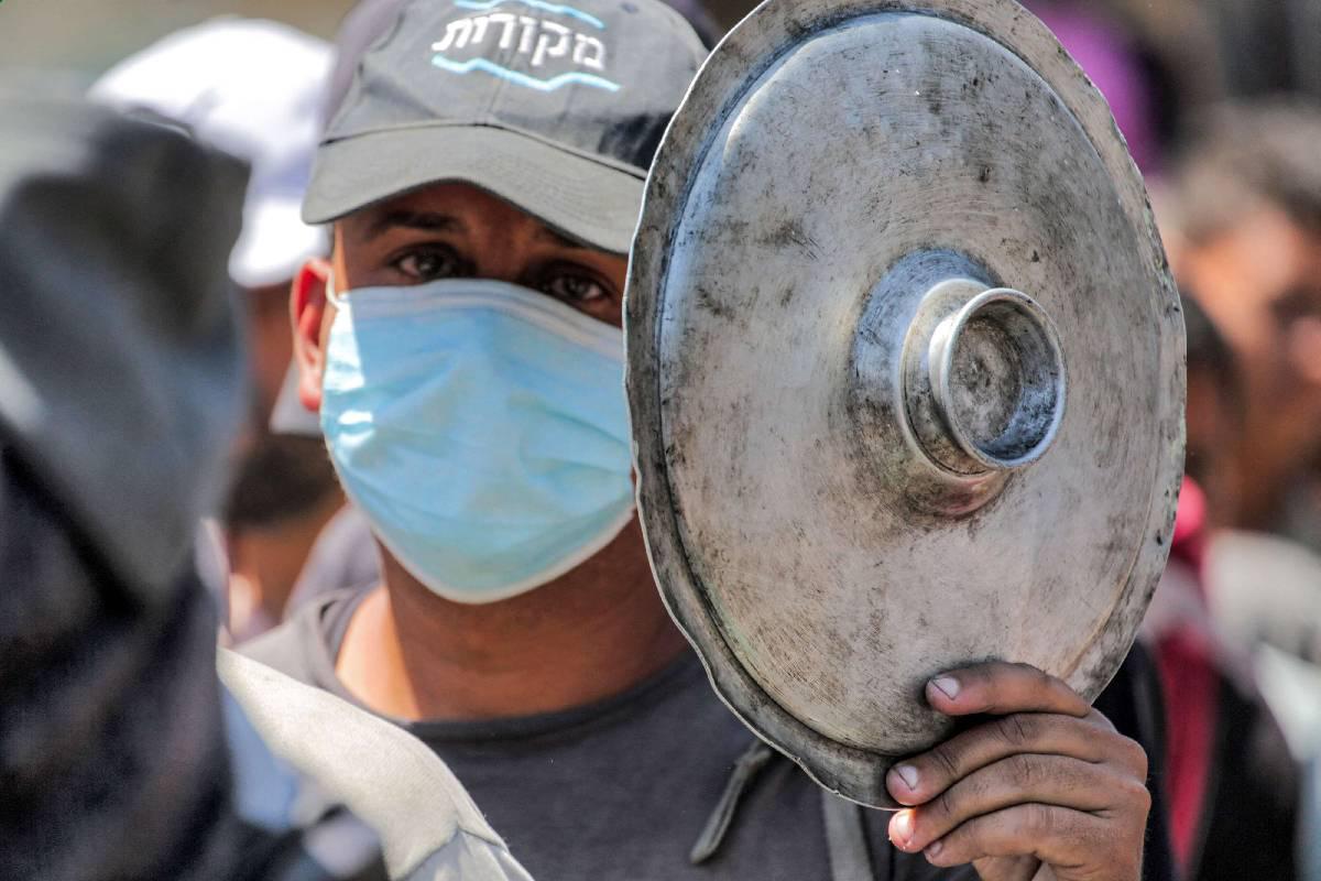 فلسطيني في طابور للطعام في مخيم دير البلح في غزة