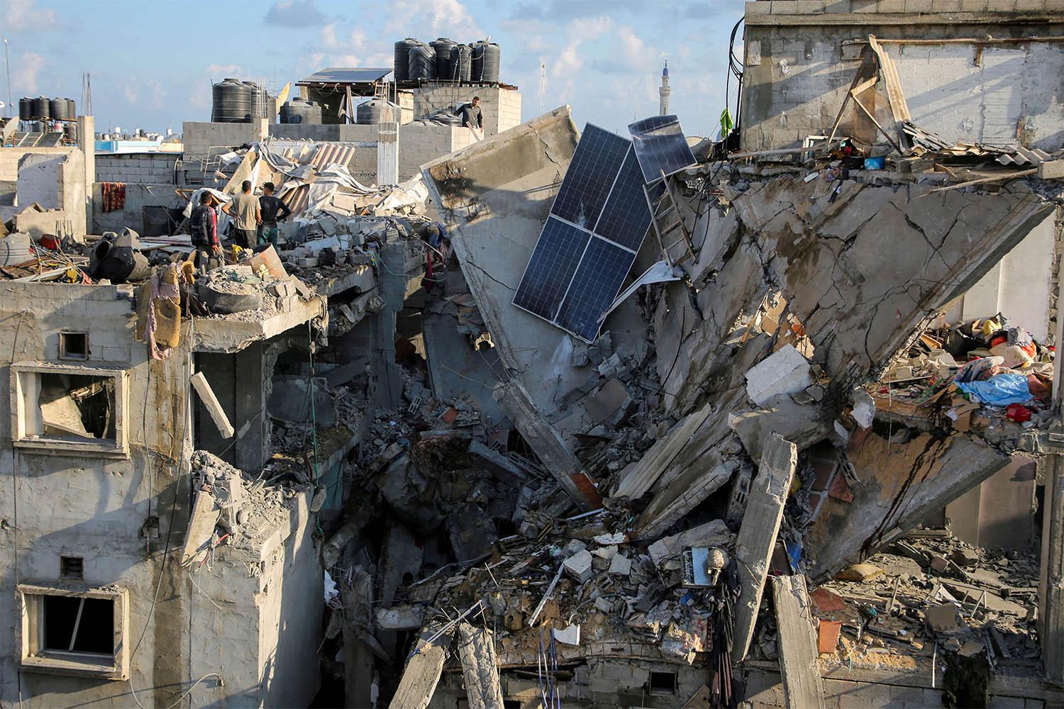 Palestinians inspect the site of an Israeli strike on a house in Rafah