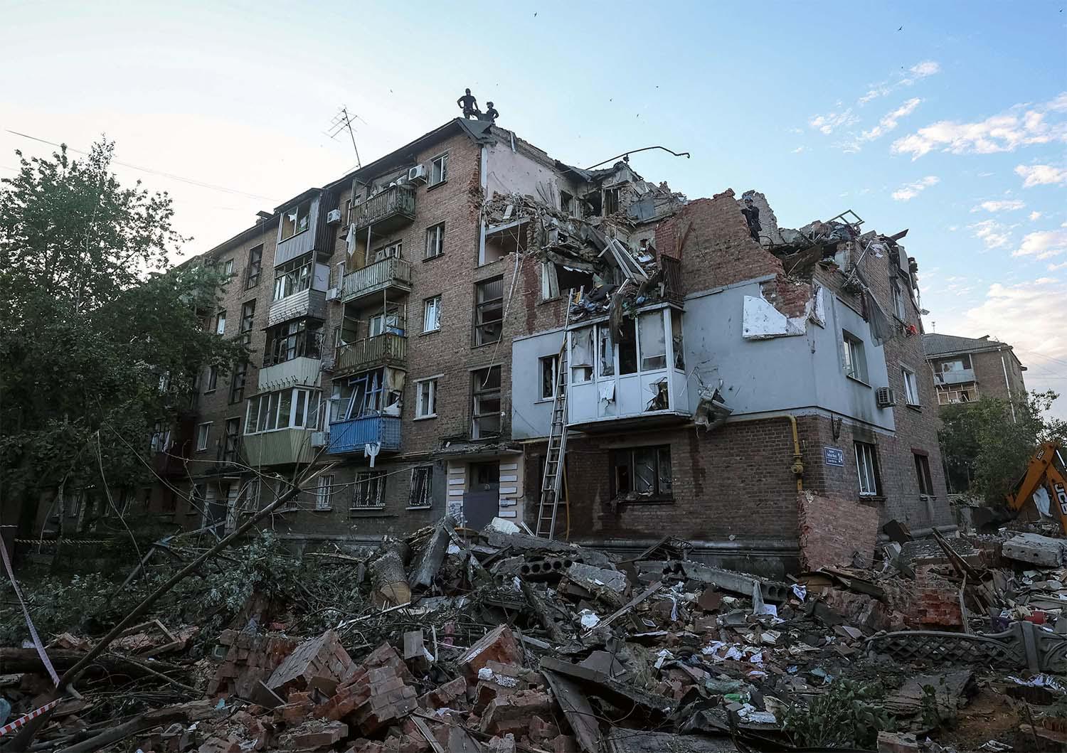 Rescuers work at a site of a residential building in kharkiv hit by a Russian missile strike