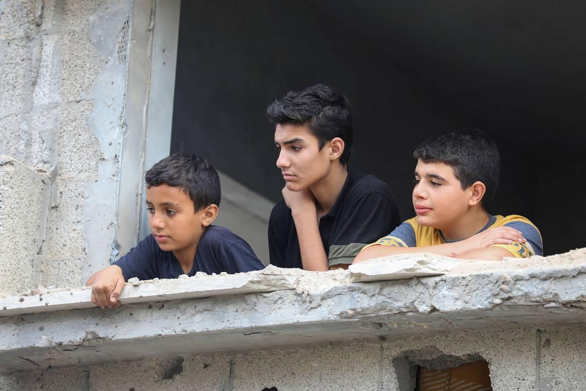 أطفال فلسطينيون في مبان مهدمة بسبب القصف الإسرائيلي في غزة