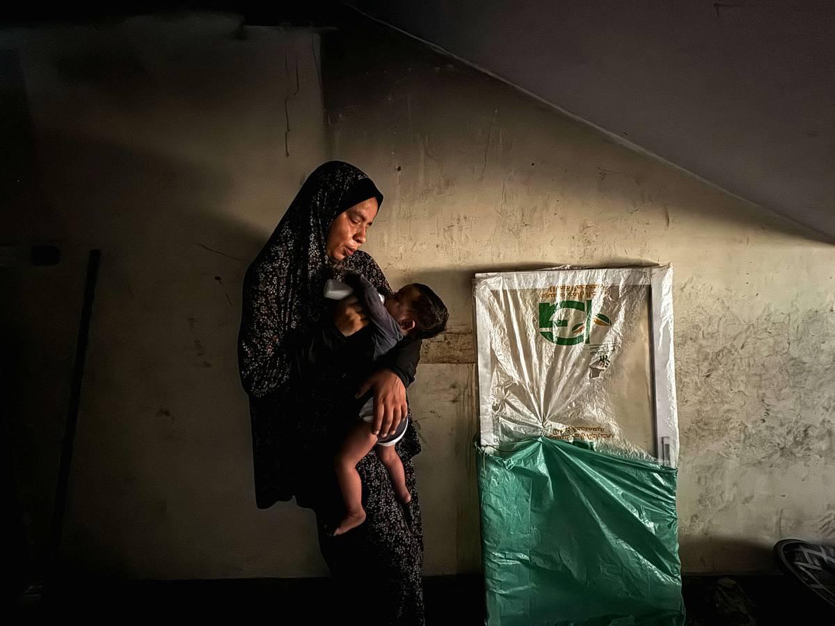 فلسطينية مع طفلها الذي يعاني من نقص التغذية