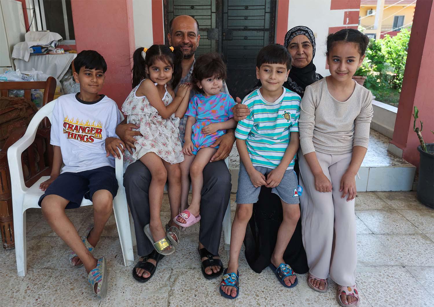 Samer Abu Della, displaced Lebanese from southern border village of Yarine, poses for a picture with his family