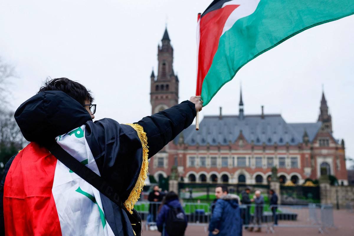 متظاهر يلوح بعلم فلسطين أمام محكمة العدل الدولية