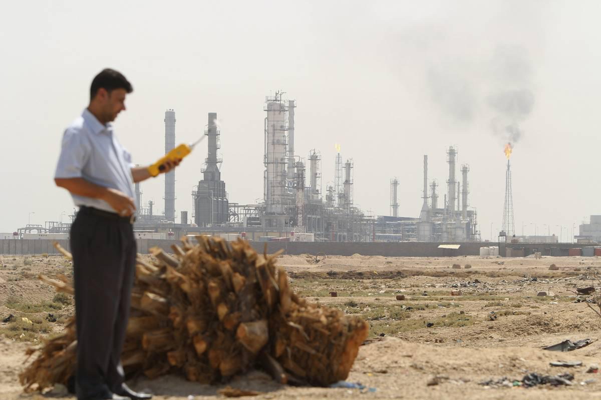 مهندس عراقي يجري قراءات مستويات التلوث بالقرب من مصفى الشعيبة في البصرة جنوب العراق