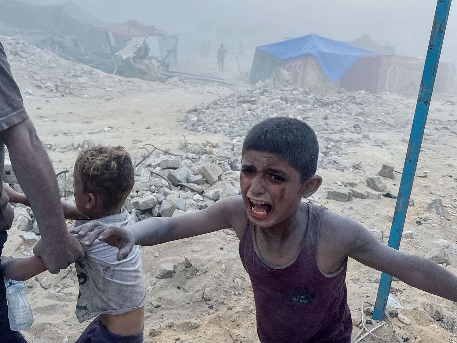 A Palestinian child cries following an Israeli strike near a UN-run school sheltering displaced people in Khan Younis