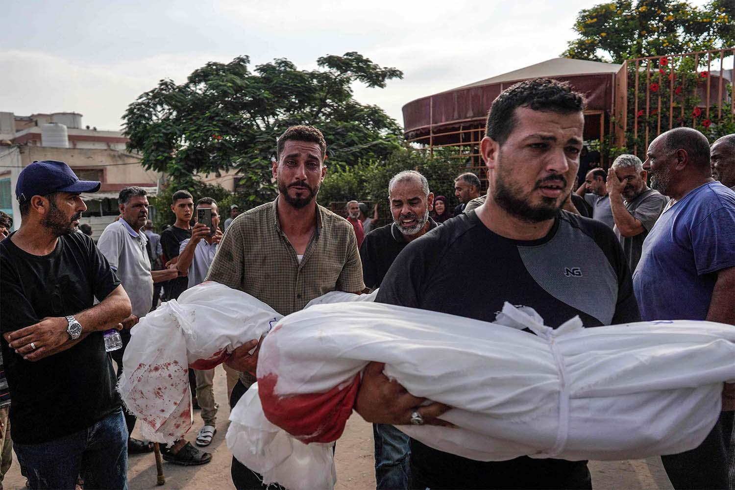 Mourners carry the bodies of members of the Qadih family to a burial ground in Khuzaa in the southern Gaza Strip