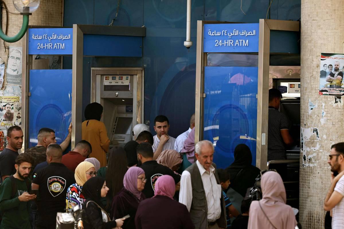 فلسطينيون يسحبون أموالا من مكائن الصرف في نابلس في الضفة الغربية