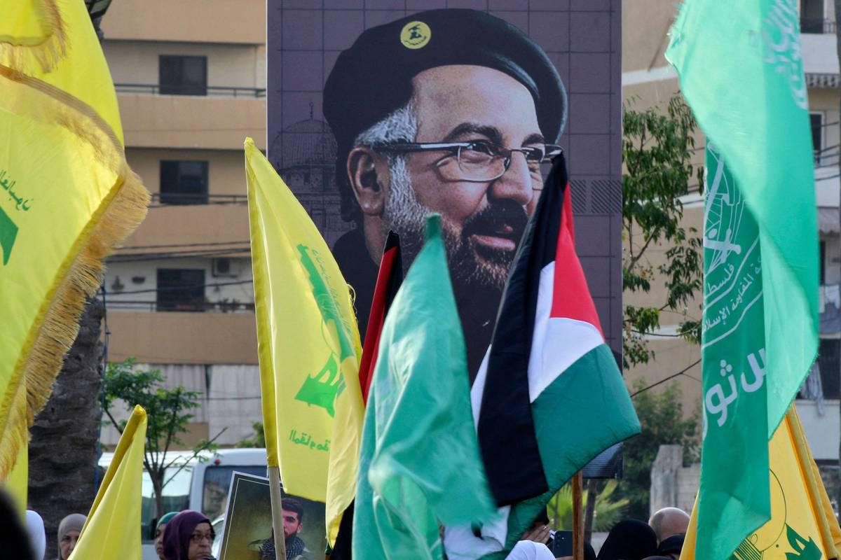 لبنانيون يرفعون صورة القيادي في حزب الله فؤاد شكر الذي اغتالته القوات الإسرائيلية