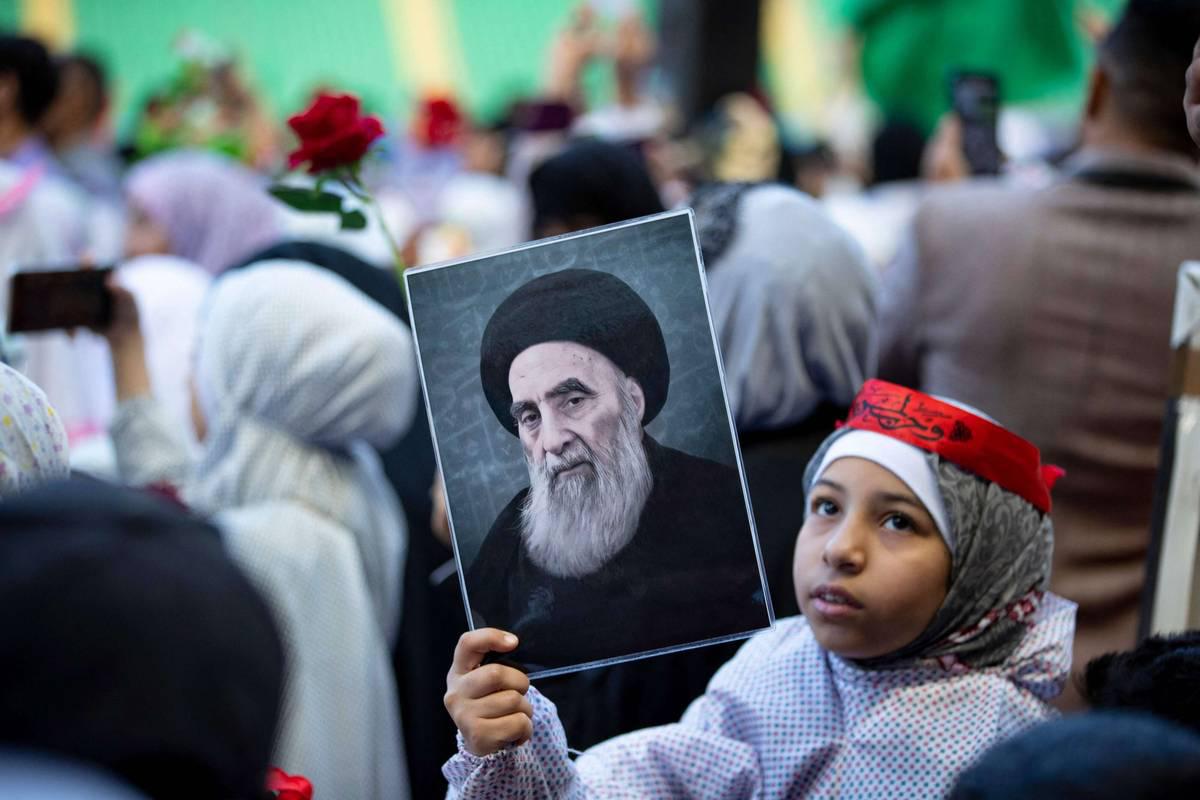طفلة عراقية ترفع صورة آية الله علي السيستاني
