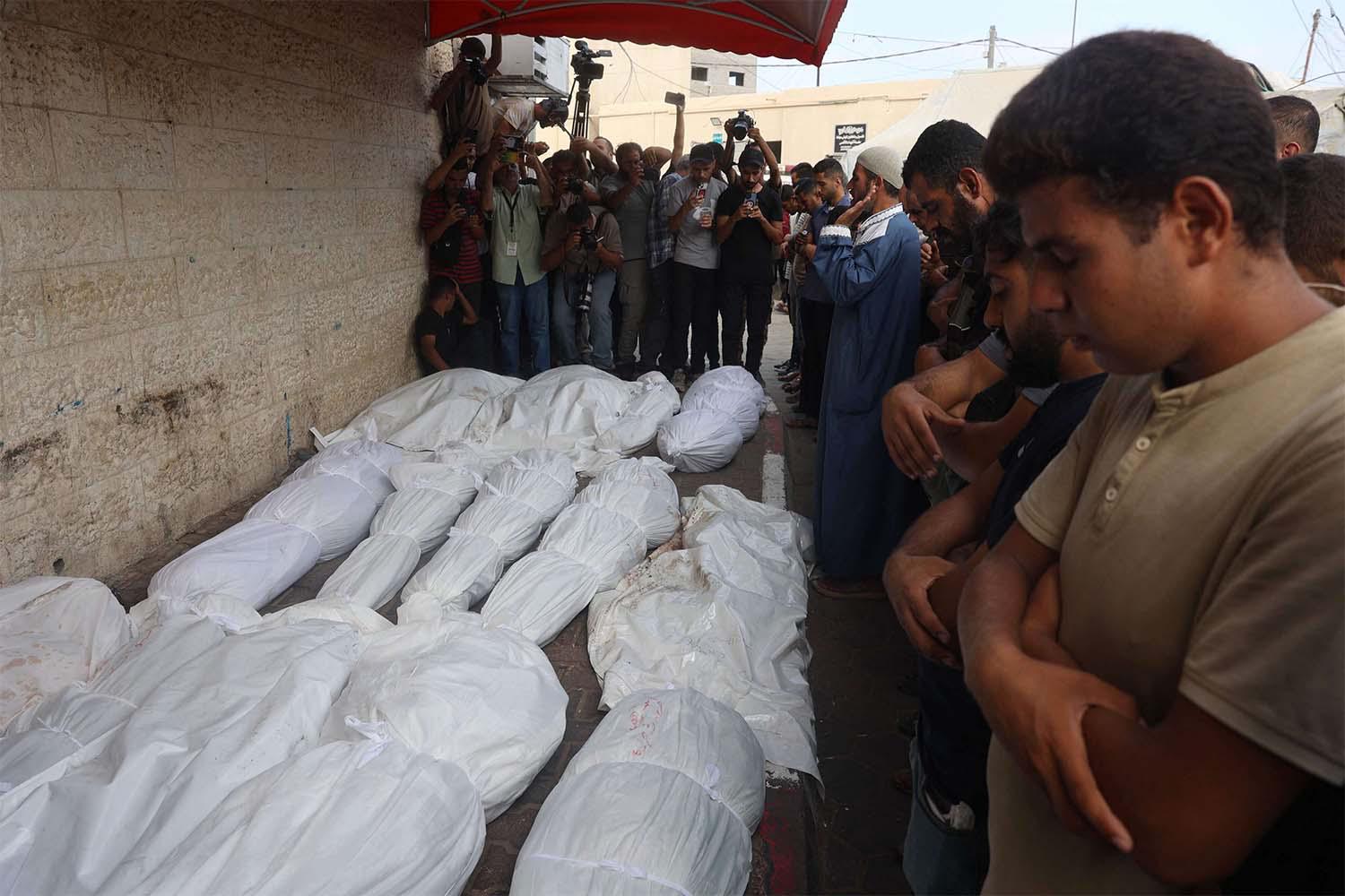 Palestinians mourn their relatives, killed in an Israeli strike on Central Gaza