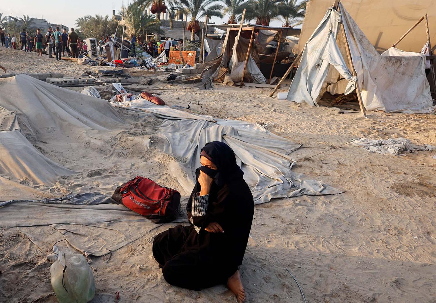 A Palestinian woman cries at the site following Israeli strikes on the tent camp sheltering displaced people