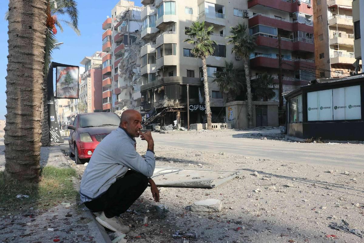 لبناني أمام مبنى مدمر في صور